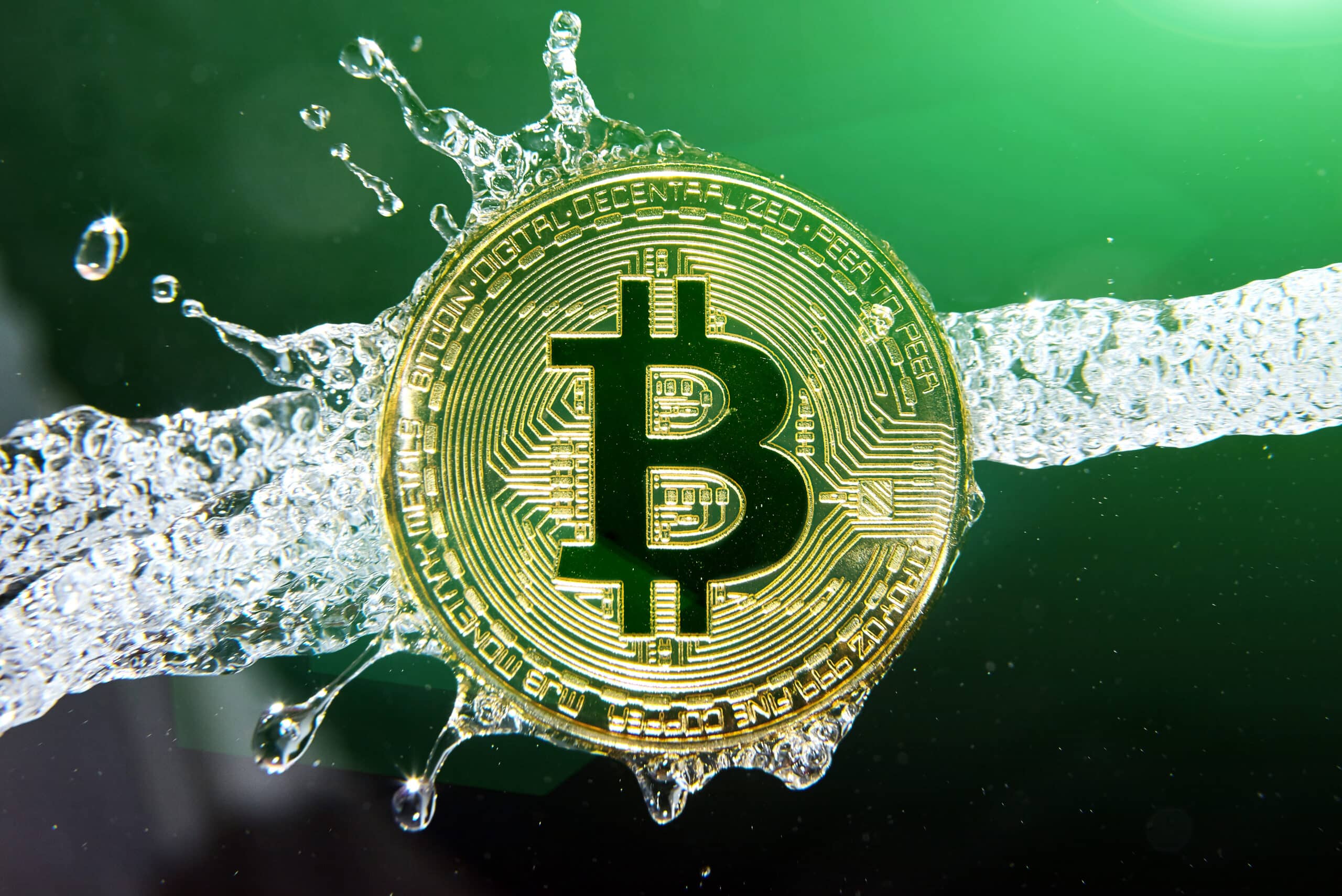 Golden bitcoin and water splash on dark background. (Shutterstock)