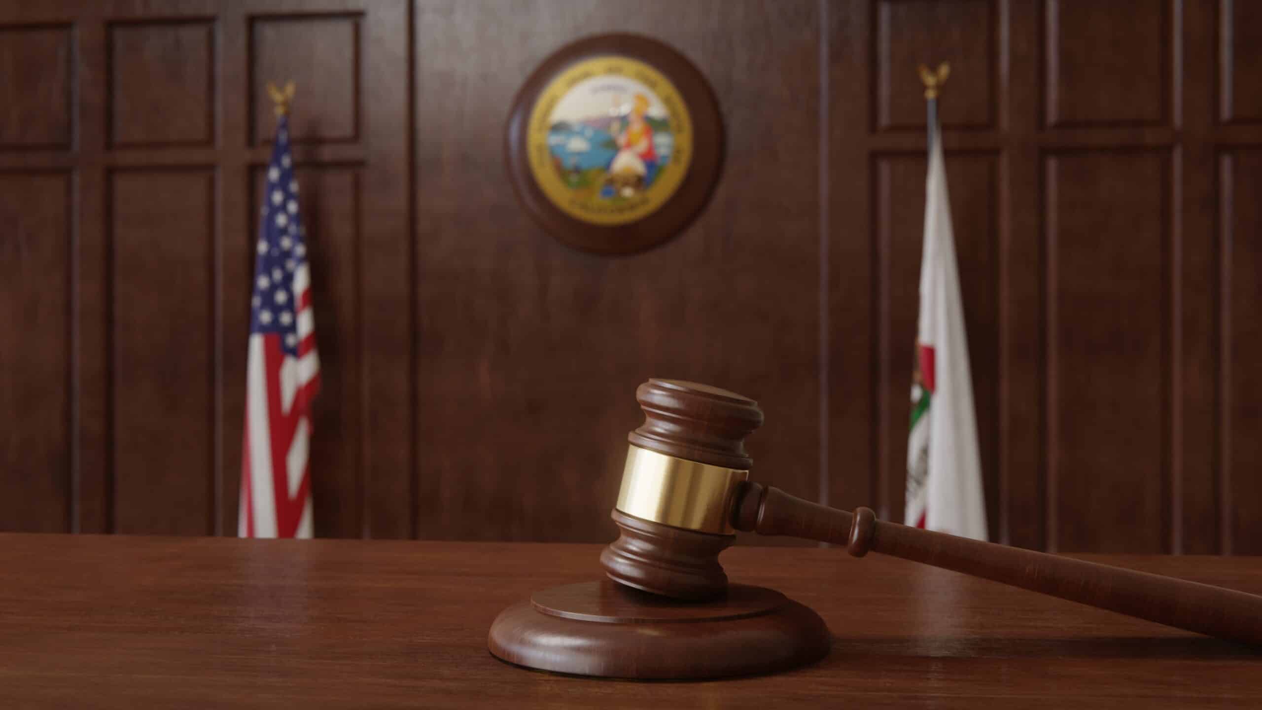 Courtroom scene with US flag and state seal and flag of the state of California. (Shutterstock/HTGanzo)